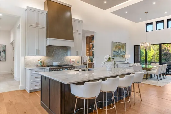 a kitchen with stainless steel appliances granite countertop a stove a sink a microwave and a dining table