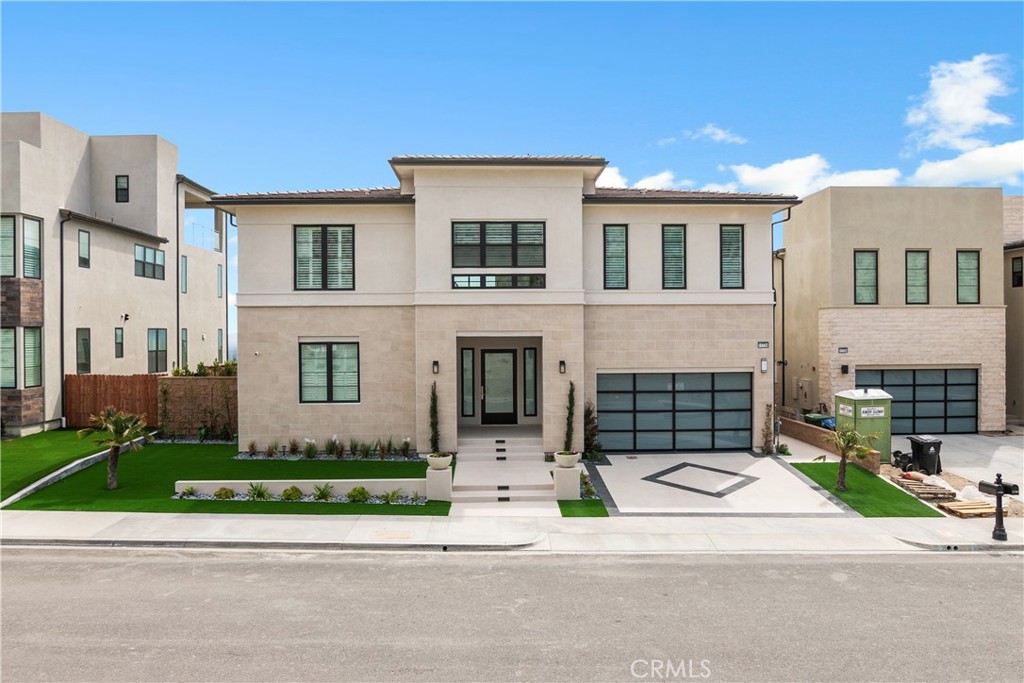 a front view of a house with a garden and parking