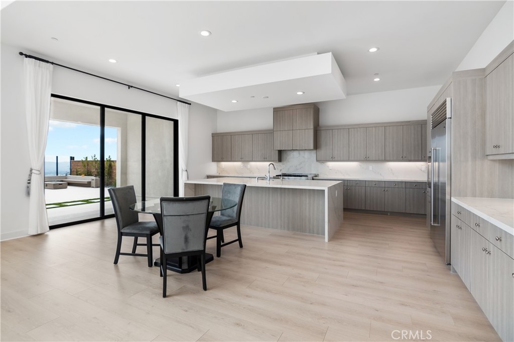 11734 Hillsborough Lane Porter Ranch, CA 91326 - Photo 11 of 34 a kitchen with a table chairs and a refrigerator