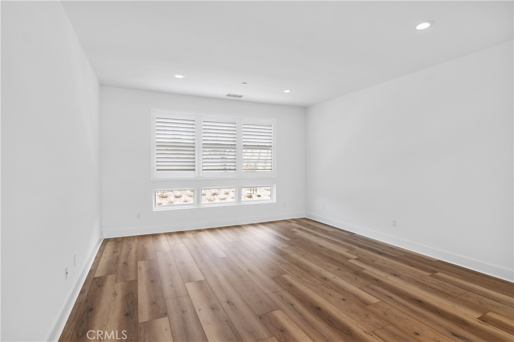 11734 Hillsborough Lane Porter Ranch, CA 91326 - Photo 30 of 34 a view of an empty room with wooden floor and a window