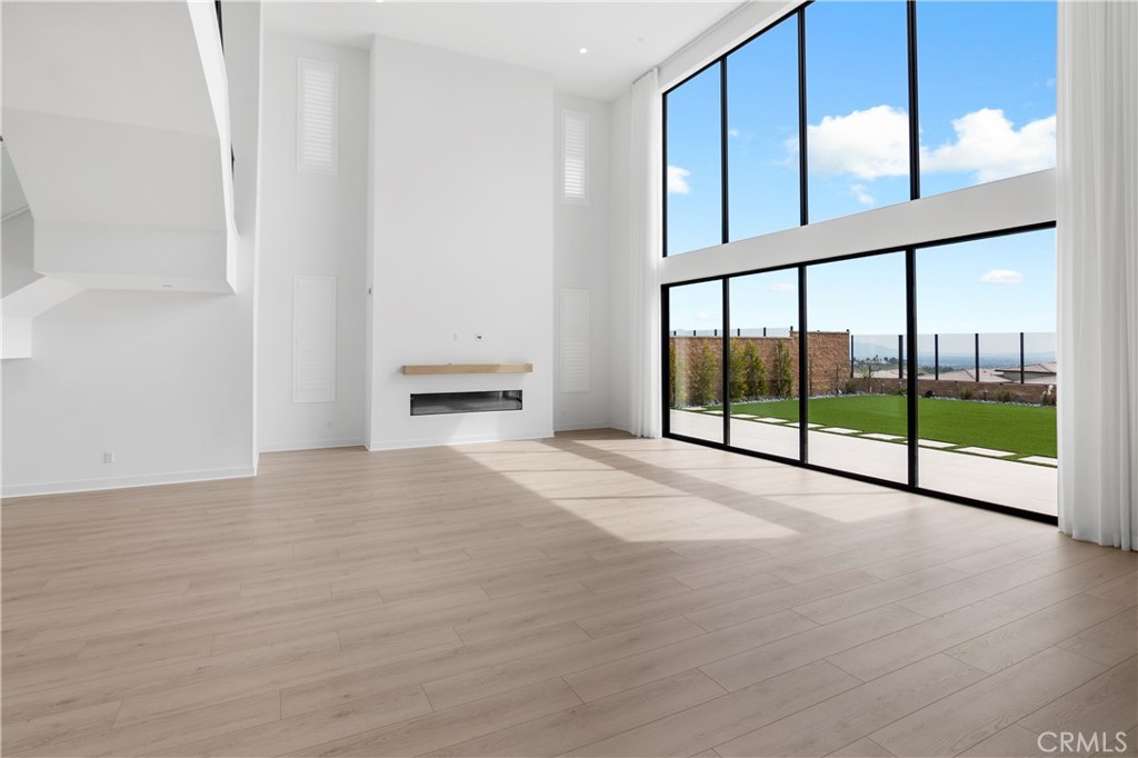 11734 Hillsborough Lane Porter Ranch, CA 91326 - Photo 7 of 34 a view of an empty room with a window and wooden floor