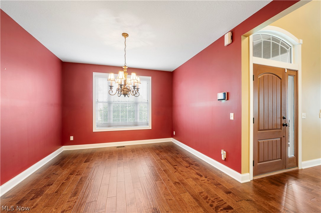 3356 Huntcliffe Road Northeast Canton, OH 44721 - Photo 29 of 50 Unfurnished dining area featuring a notable chandelier and hardwood / wood-style floors