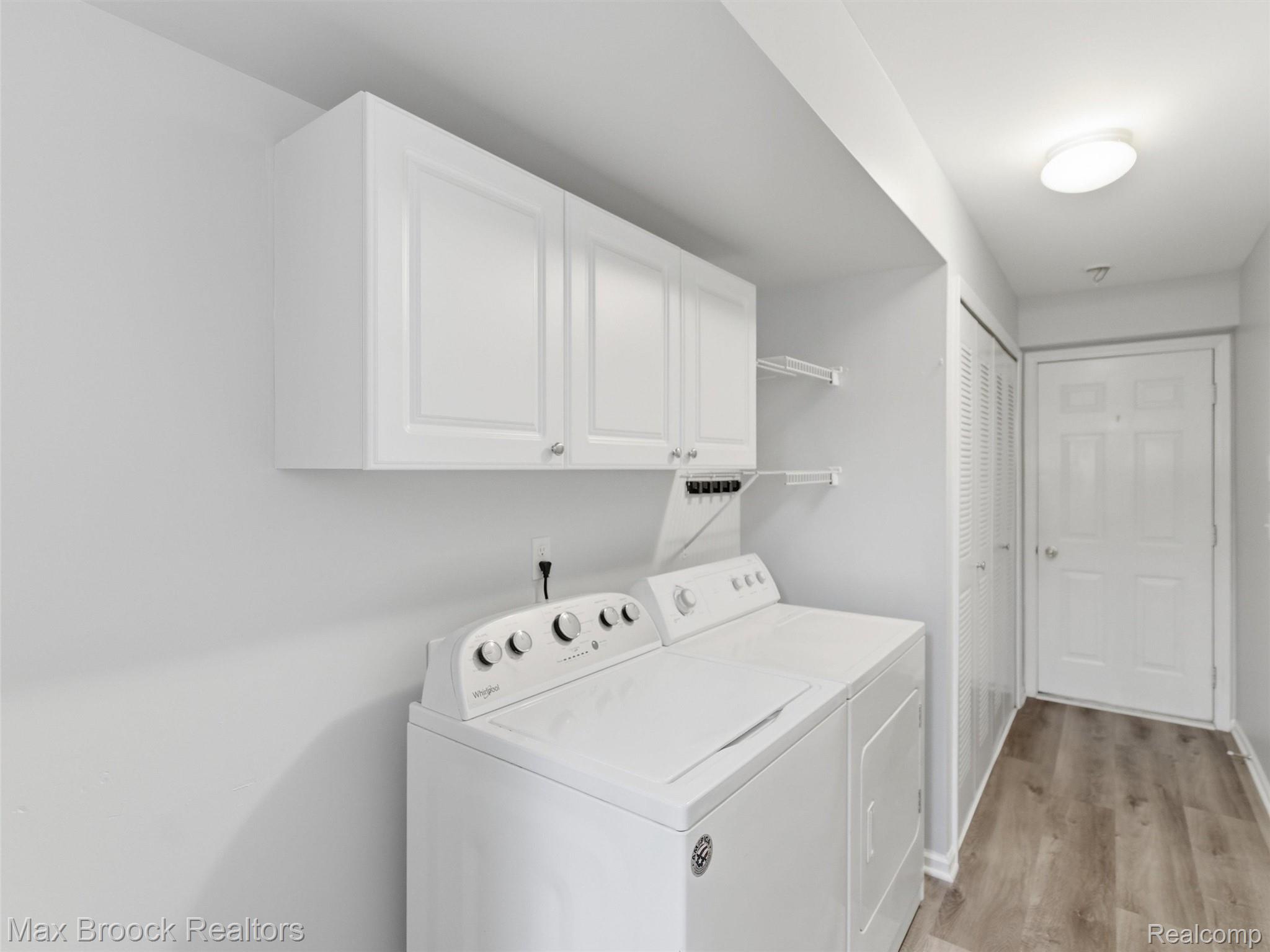 3562 Tremonte Circle Rochester, MI 48306 - Photo 23 of 33 Dedicated laundry space featuring white upper cabinetry, open shelving, a white washer and dryer, and wood-finish flooring