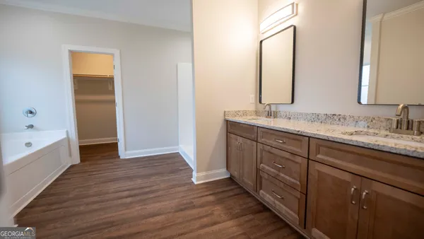 a spacious bathroom with a granite countertop sink and a mirror
