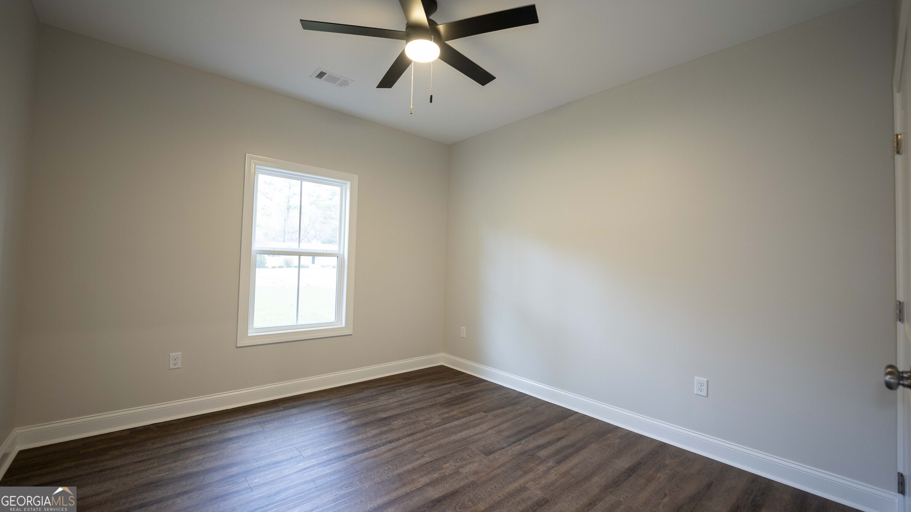 288 Frank Cook Road Cochran, GA 31014 - Photo 24 of 40 an empty room with wooden floor fan and windows