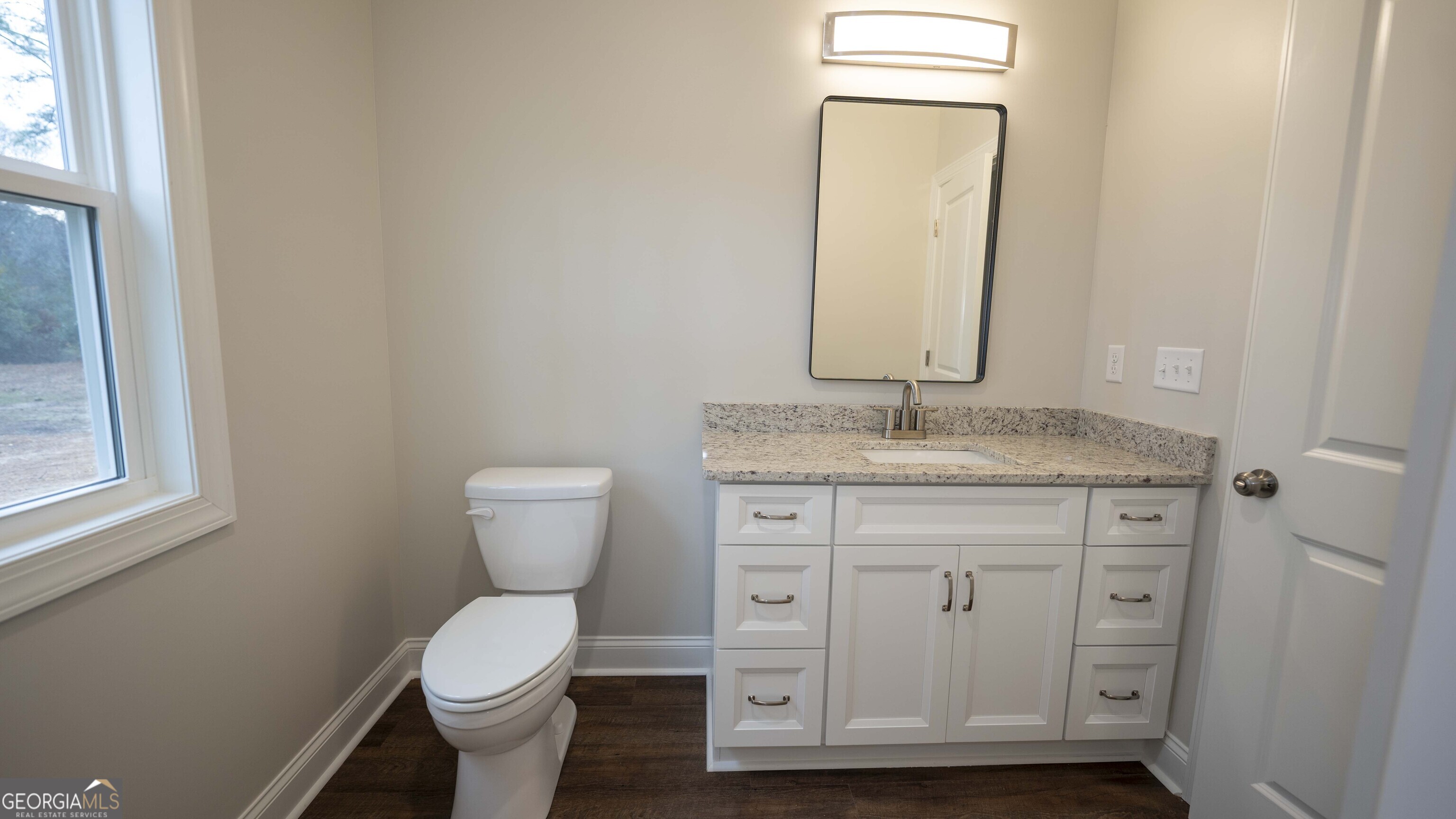 288 Frank Cook Road Cochran, GA 31014 - Photo 27 of 40 a bathroom with a granite countertop toilet sink and mirror