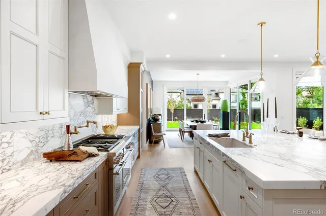 a large kitchen with stainless steel appliances granite countertop a lot of counter space and a sink