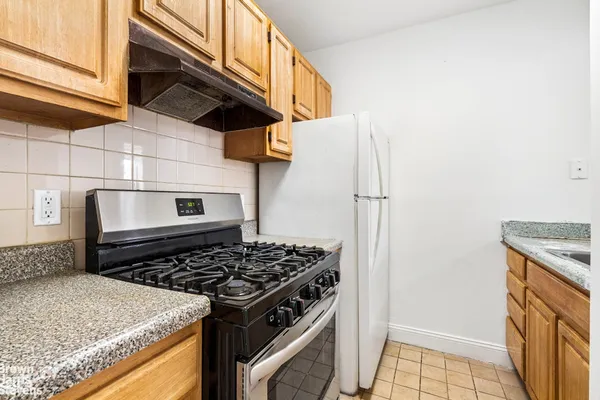 a kitchen with stainless steel appliances granite countertop a stove and a refrigerator