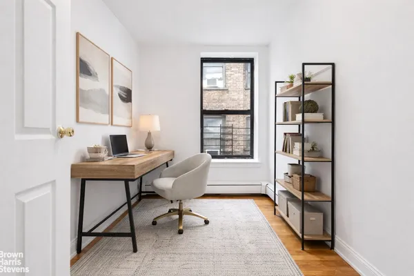 a view of a workspace with furniture and a window
