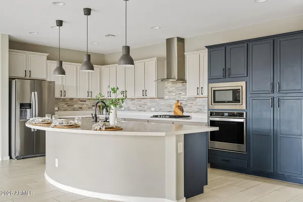 a kitchen with kitchen island a white cabinets and stainless steel appliances