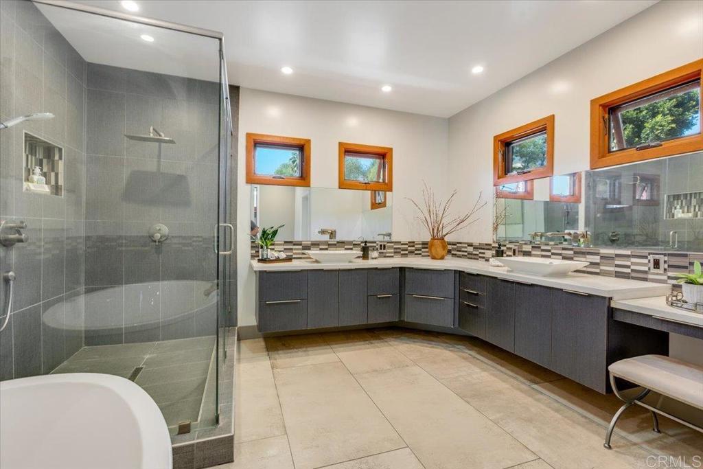 5382 Willman Way Fallbrook, CA 92028 - Photo 20 of 64 a large bathroom with a granite countertop tub a sink a mirror and a shower