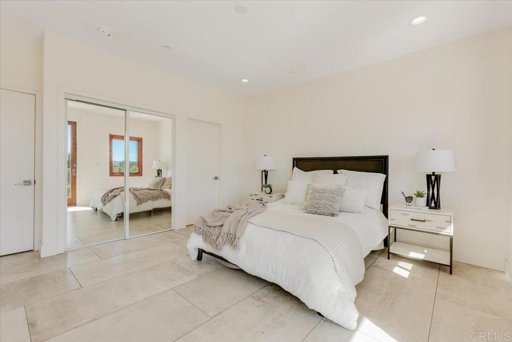 5382 Willman Way Fallbrook, CA 92028 - Photo 25 of 64 a bedroom with a bed and a chair