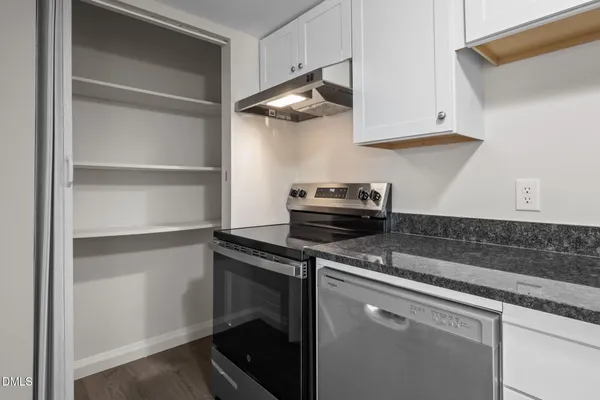 a kitchen with cabinets and a stove top oven