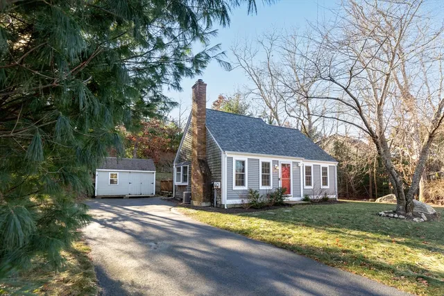 a view of a house with a yard and large tree