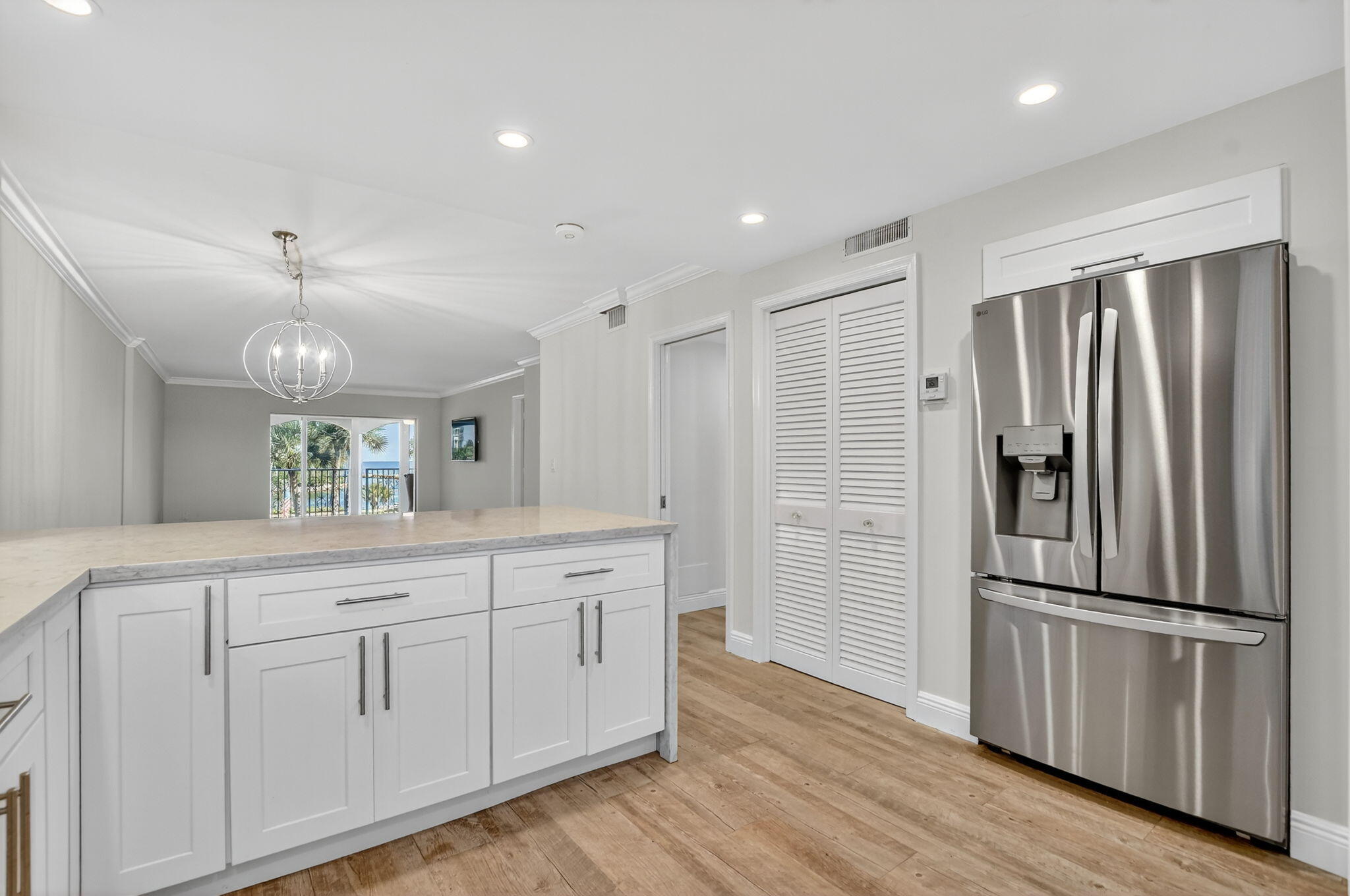 1040 Banyan Road, Unit 3050 Boca Raton, FL 33432 - Photo 11 of 35 a kitchen with white cabinets stainless steel appliances and wooden floor