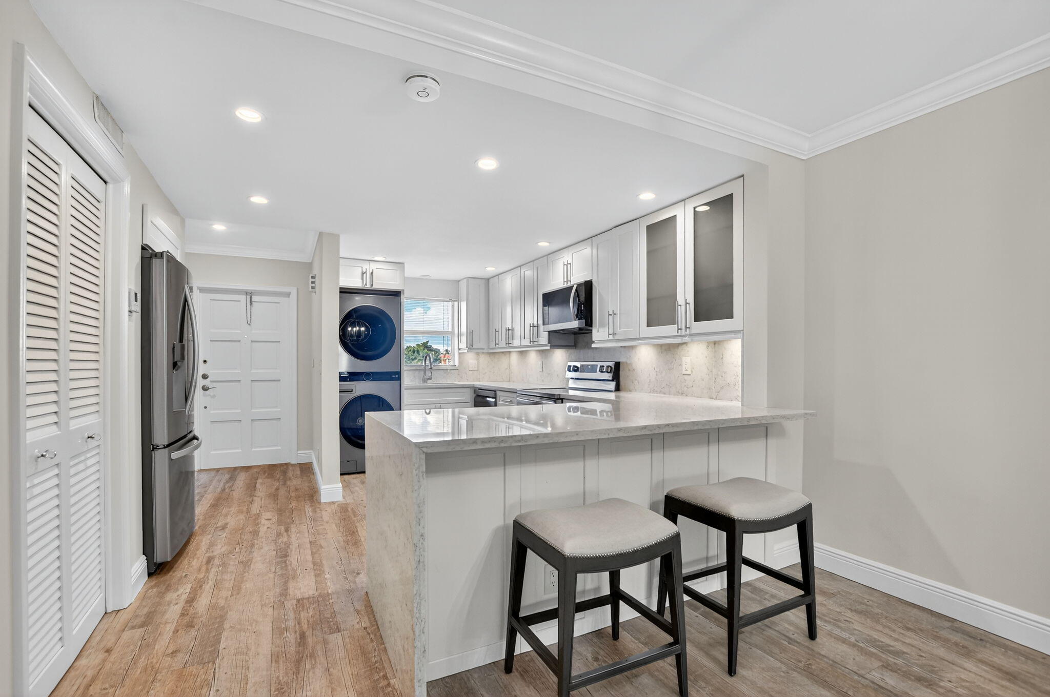 1040 Banyan Road, Unit 3050 Boca Raton, FL 33432 - Photo 13 of 35 a kitchen with stainless steel appliances granite countertop a kitchen island hardwood floor sink and stove