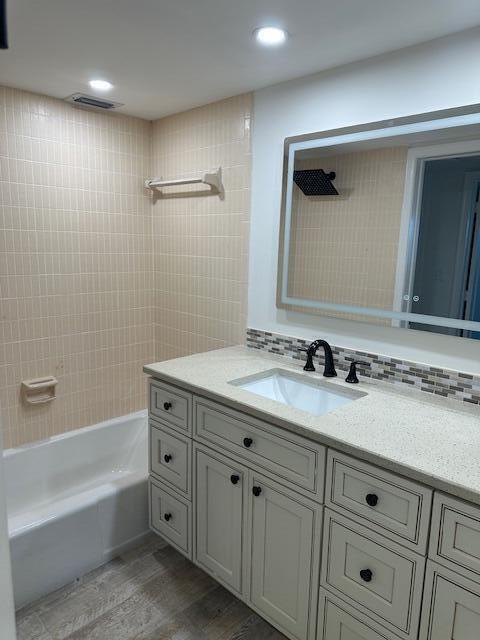 1040 Banyan Road, Unit 3050 Boca Raton, FL 33432 - Photo 25 of 35 a bathroom with a granite countertop sink a mirror and a bathtub