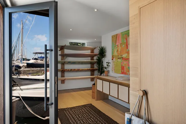 a view of a hallway with wooden floor and a bathroom