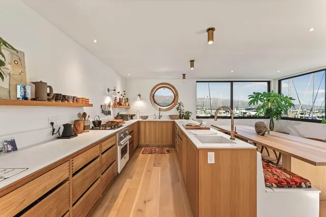 a large kitchen with stainless steel appliances a large window in it
