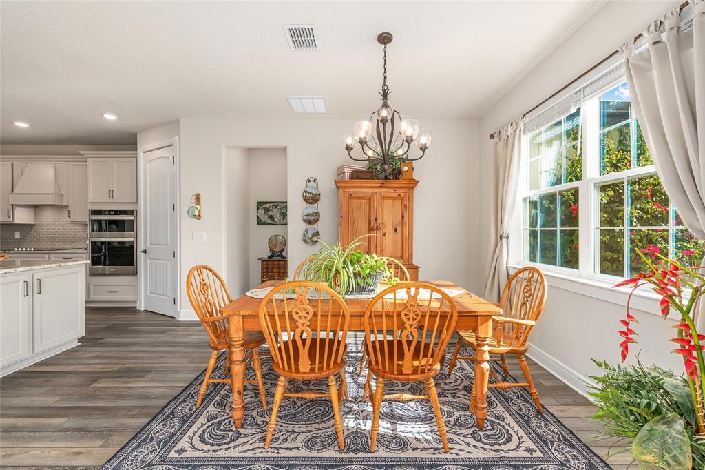 8986 Southwest 58th Street Road Ocala, FL 34481 - Photo 15 of 53 a view of a dining room with furniture window and wooden floor