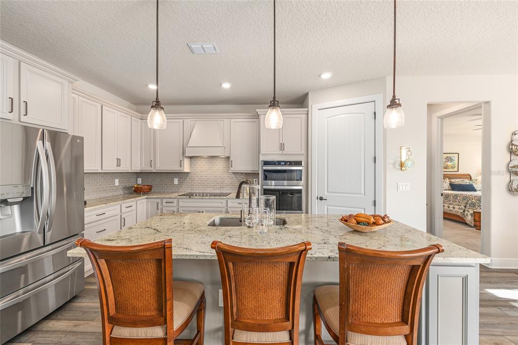 8986 Southwest 58th Street Road Ocala, FL 34481 - Photo 17 of 53 a kitchen with refrigerator a sink and chairs