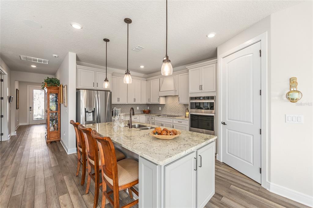 8986 Southwest 58th Street Road Ocala, FL 34481 - Photo 18 of 53 a kitchen with stainless steel appliances granite countertop a sink a stove a refrigerator and island with wooden floor