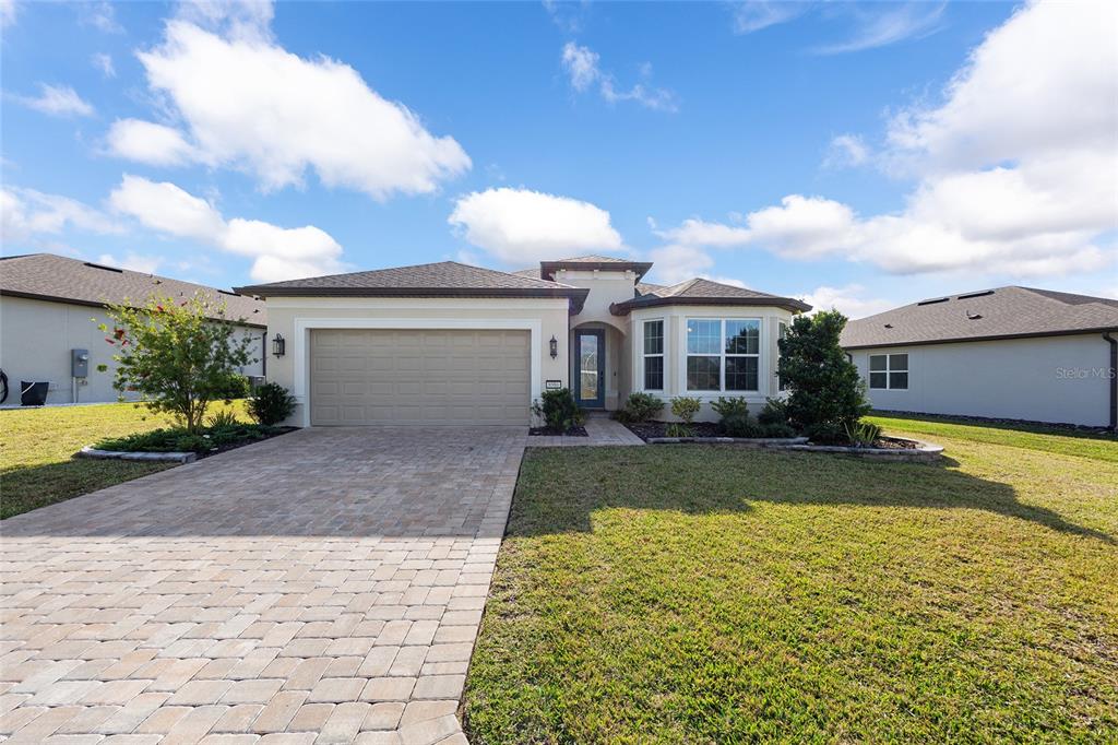 8986 Southwest 58th Street Road Ocala, FL 34481 - Photo 2 of 53 a front view of a house with a yard and garage