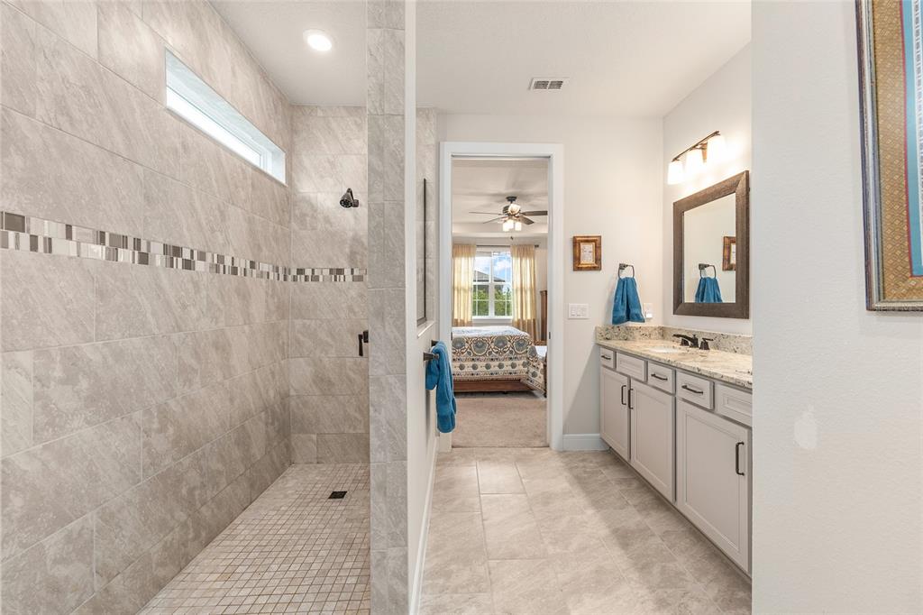 8986 Southwest 58th Street Road Ocala, FL 34481 - Photo 27 of 53 a bathroom with a granite countertop shower a sink and a mirror
