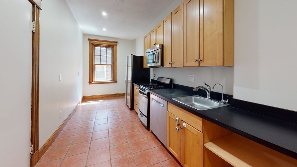 a kitchen with stainless steel appliances granite countertop a sink stove and cabinets