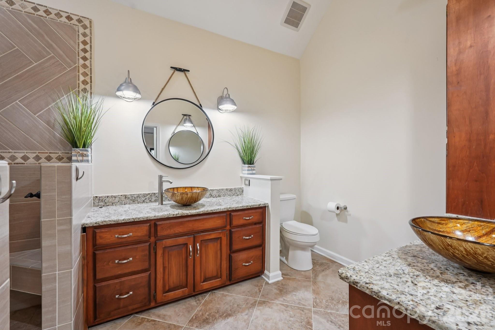 11655 Terrill Ridge Drive Davidson, NC 28036 - Photo 21 of 40 a bathroom with a granite countertop toilet sink and mirror