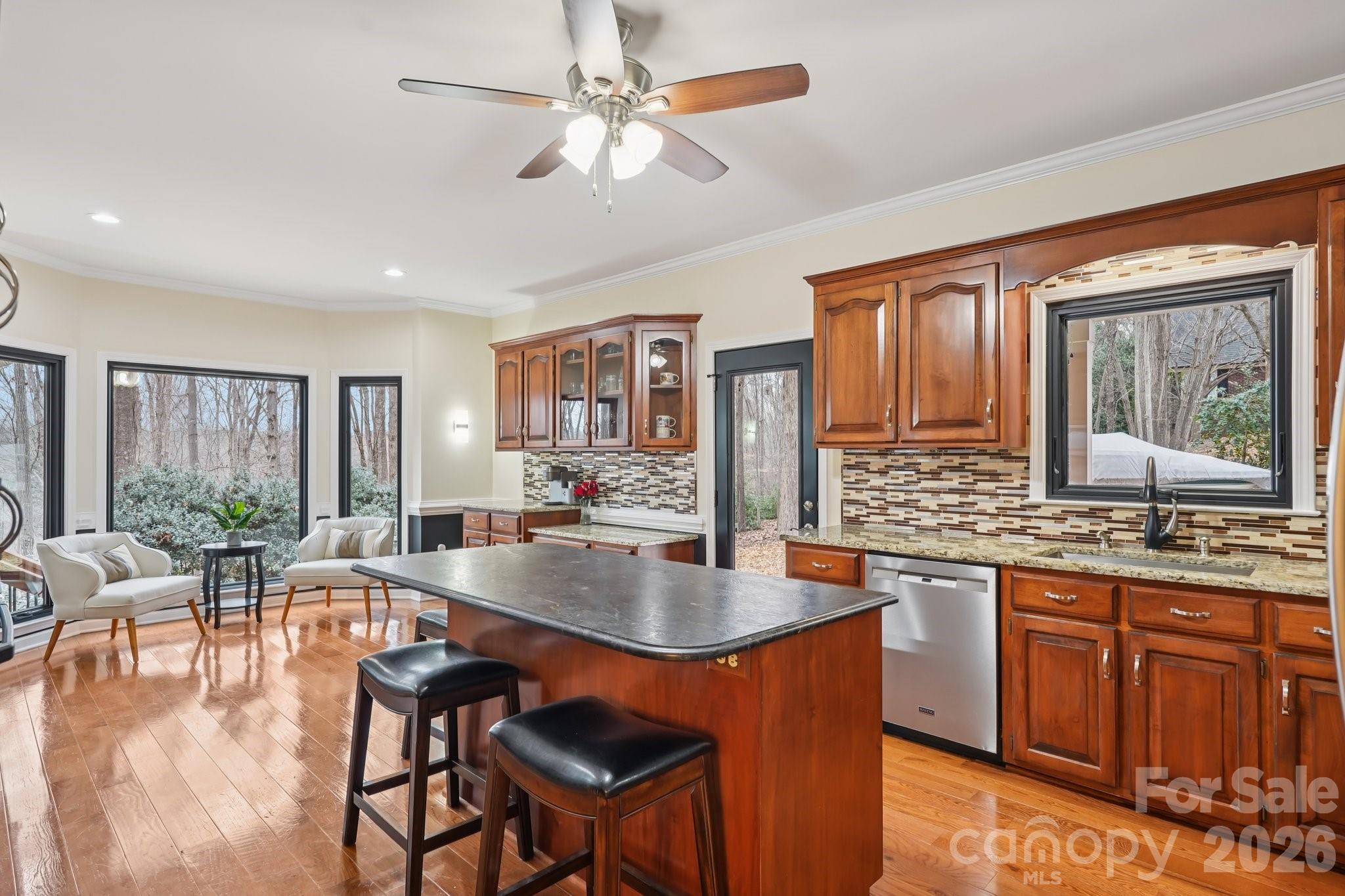 11655 Terrill Ridge Drive Davidson, NC 28036 - Photo 8 of 40 a large kitchen with granite countertop a stove a sink a dining table and chairs