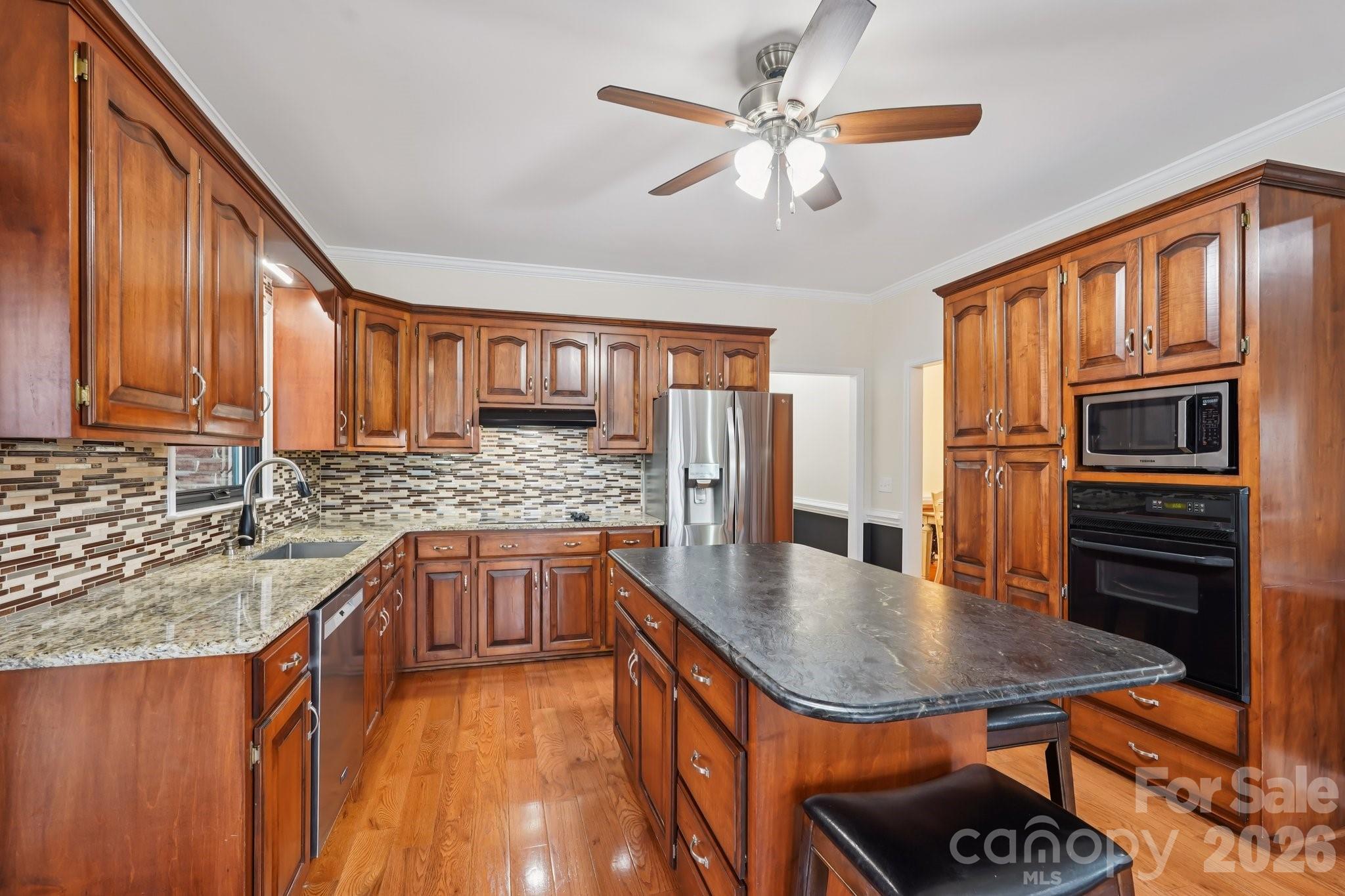 11655 Terrill Ridge Drive Davidson, NC 28036 - Photo 10 of 40 a kitchen with stainless steel appliances granite countertop a sink stove and refrigerator