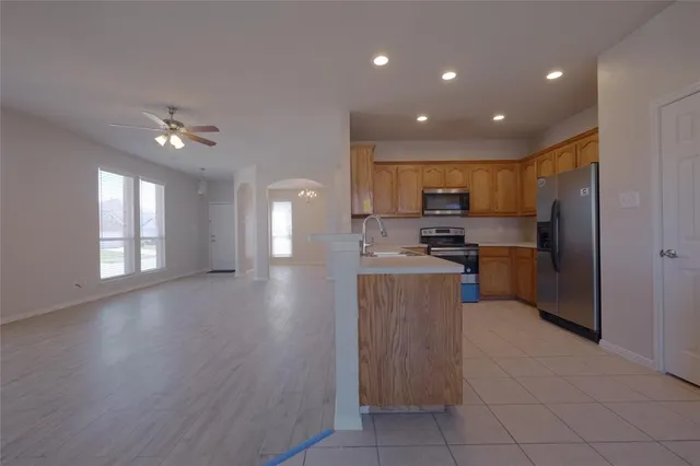 a kitchen with a refrigerator a sink and a stove top oven with wooden floor