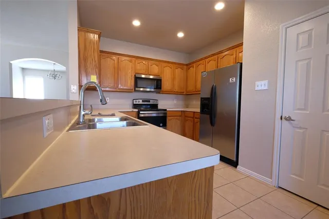 a kitchen with stainless steel appliances a refrigerator and a stove top oven