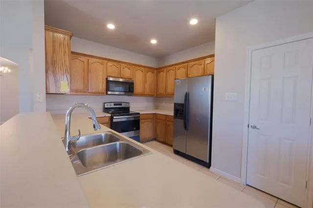 a kitchen with granite countertop stainless steel appliances a refrigerator a stove a microwave and cabinets