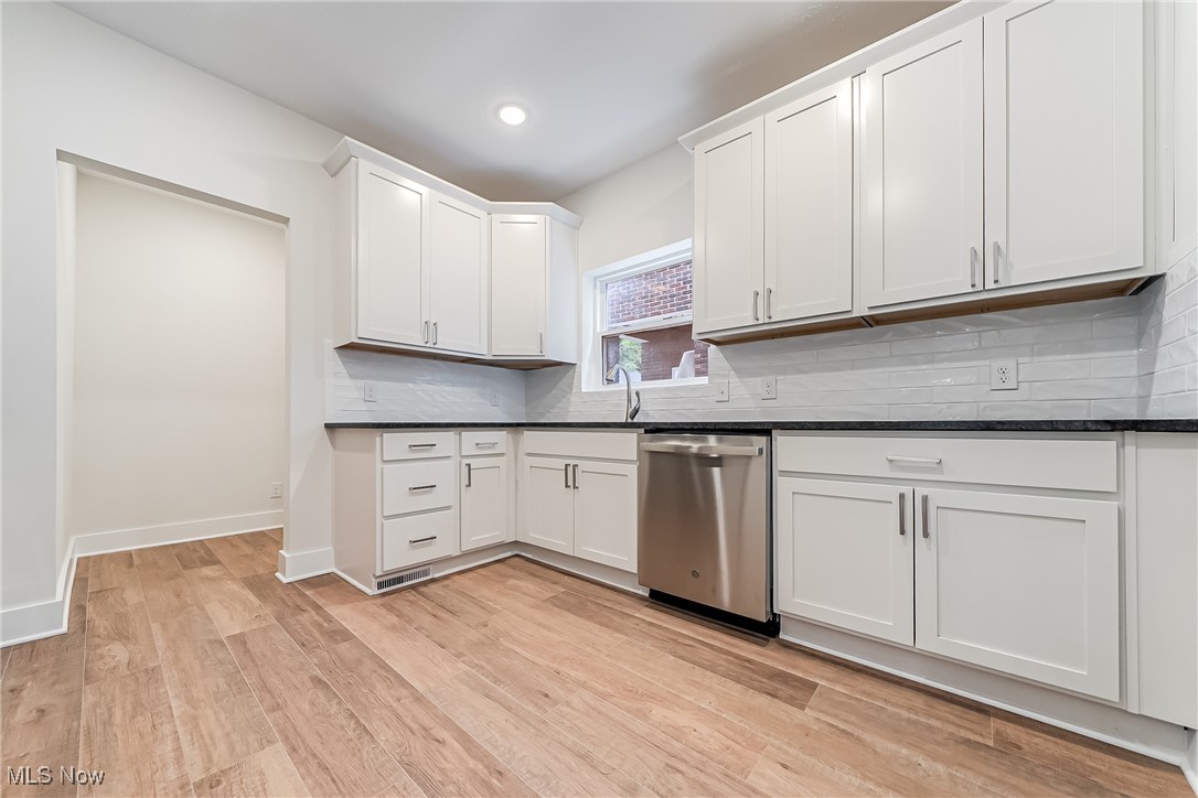 1839 Farmington Road Cleveland, OH 44112 - Photo 13 of 29 Kitchen featuring white cabinets, dishwasher, tasteful backsplash, light wood-look floors, and recessed lighting