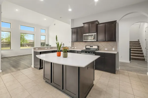 a kitchen with stainless steel appliances a sink a stove a microwave and cabinets