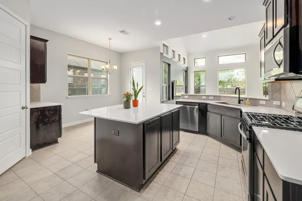 a kitchen with stainless steel appliances a sink stove and cabinets