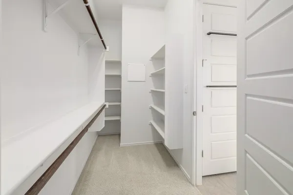 a view of walk in closet with empty racks