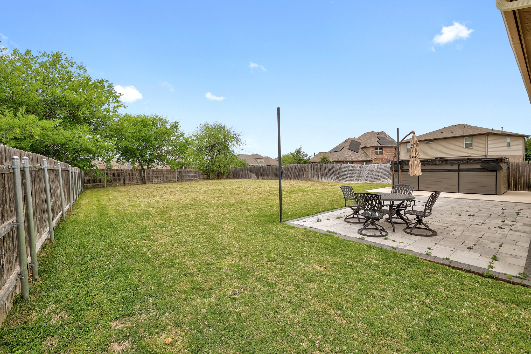 17309 Silent Harbor Loop Pflugerville, TX 78660 - Photo 32 of 38 a view of a patio with table and chairs with wooden fence and plants