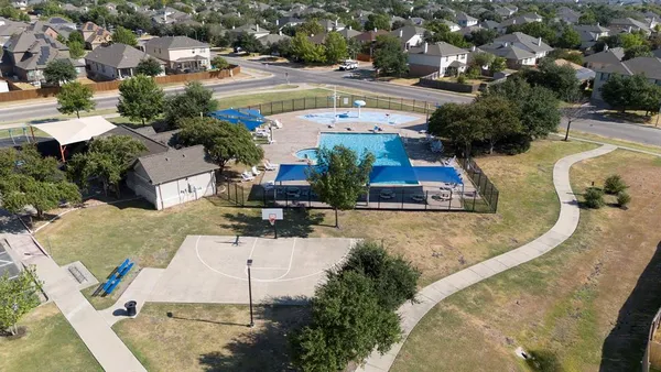 an aerial view of a residential houses with outdoor space and swimming pool