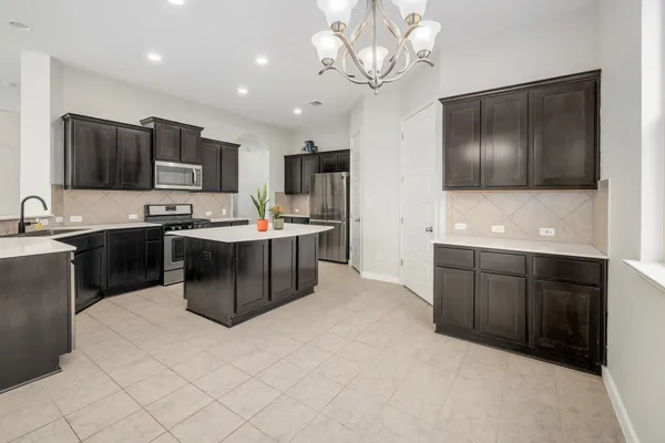 a kitchen with kitchen island granite countertop stainless steel appliances a sink cabinets and a counter top space