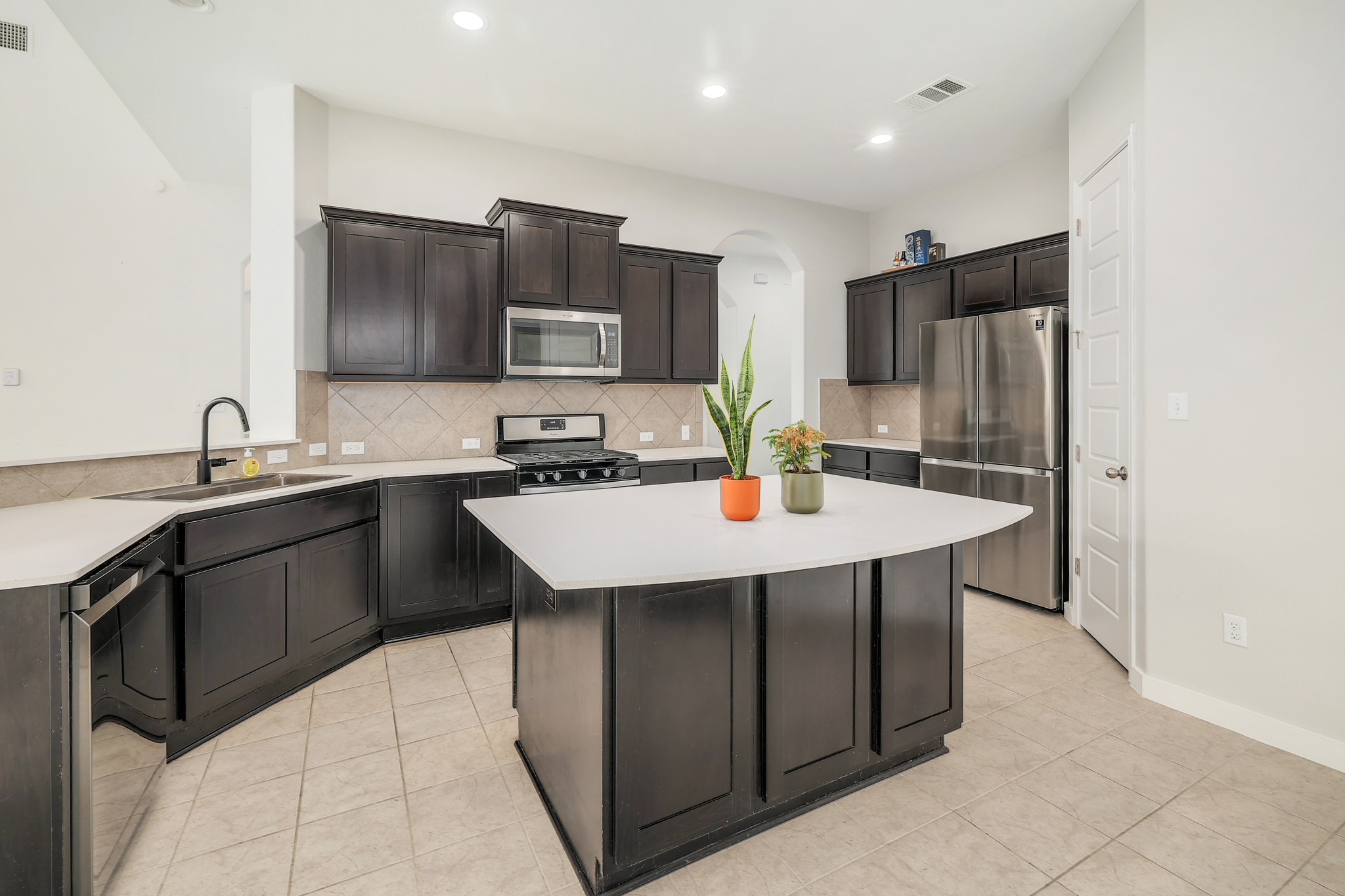 17309 Silent Harbor Loop Pflugerville, TX 78660 - Photo 10 of 38 a kitchen with stainless steel appliances a sink a microwave a refrigerator and a stove