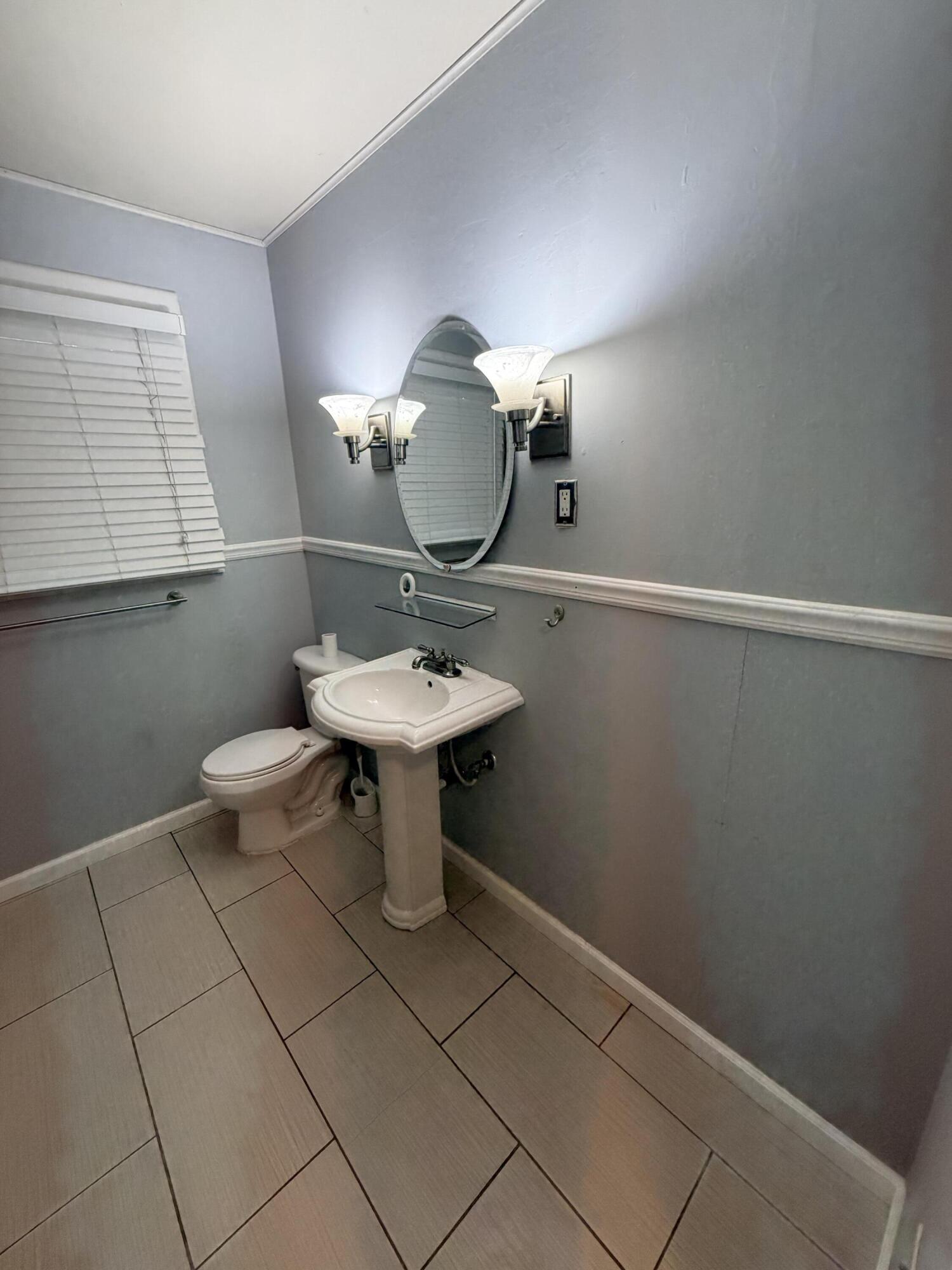 3814 27th Street Lubbock, TX 79410 - Photo 21 of 24 a bathroom with a toilet sink and mirror