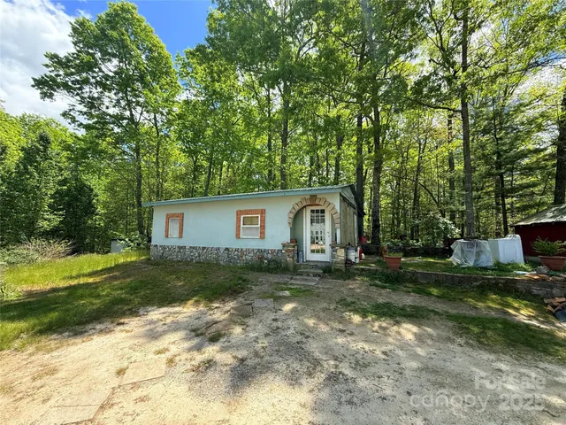 a view of a house with a yard and large trees