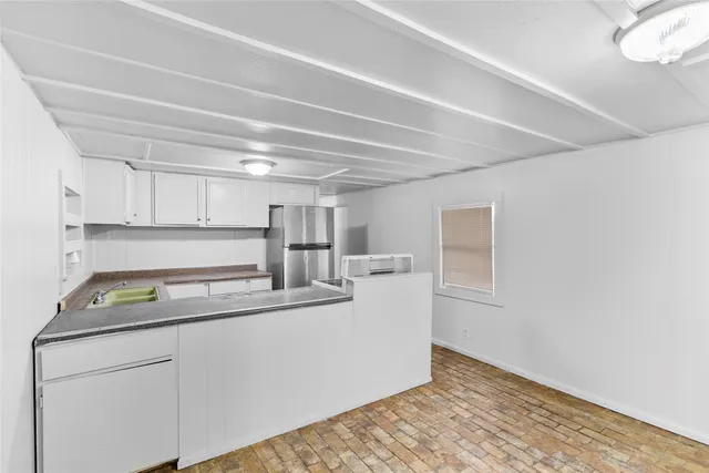 a kitchen with kitchen island white cabinets appliances and a sink