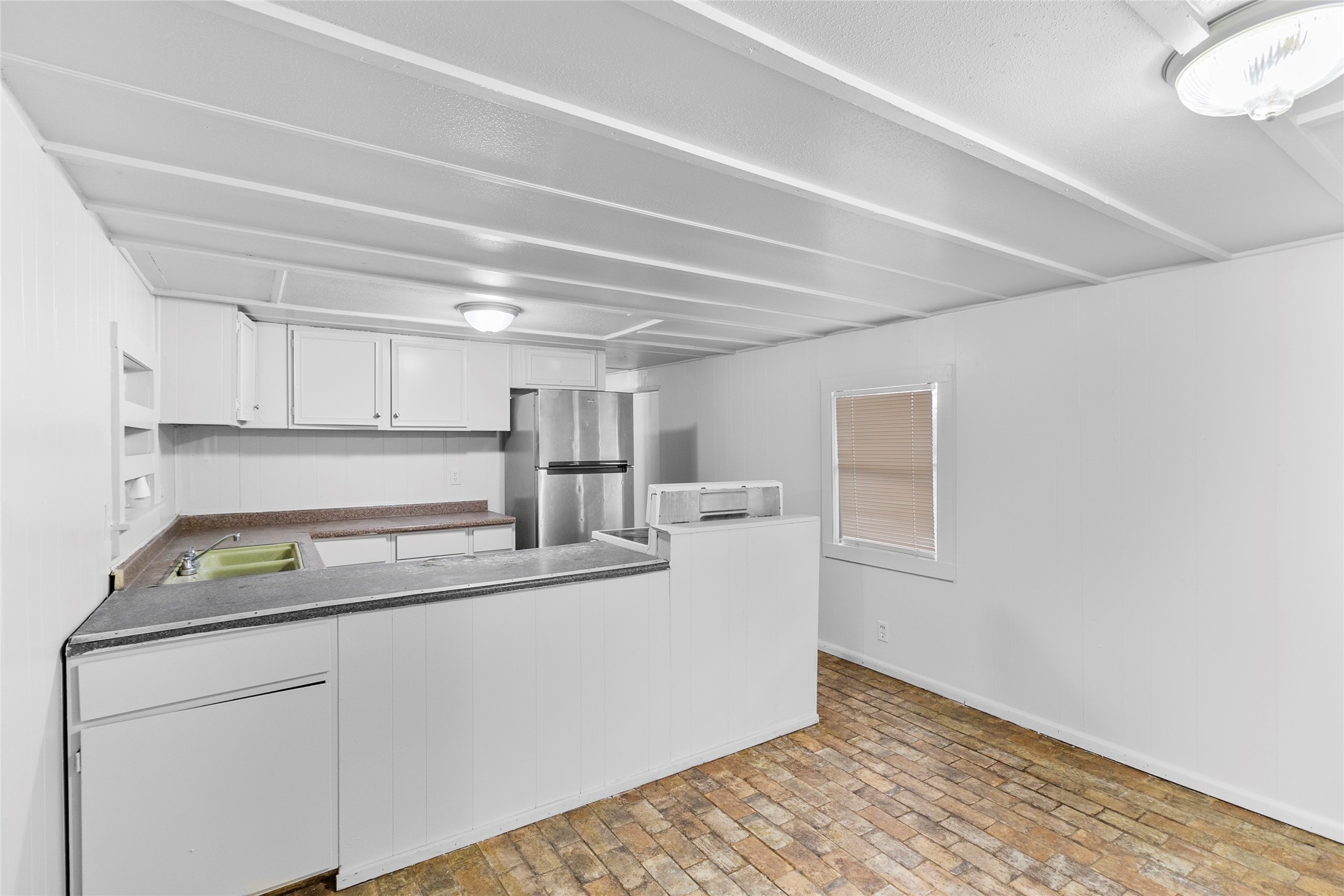 31C Jackson Road, Unit C Huntsville, TX 77320 - Photo 6 of 16 a kitchen with kitchen island white cabinets appliances and a sink