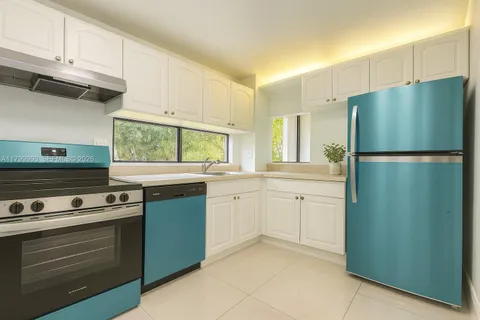 a kitchen with a stove refrigerator and microwave