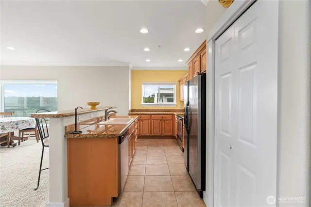 a kitchen with stainless steel appliances granite countertop a sink and a refrigerator