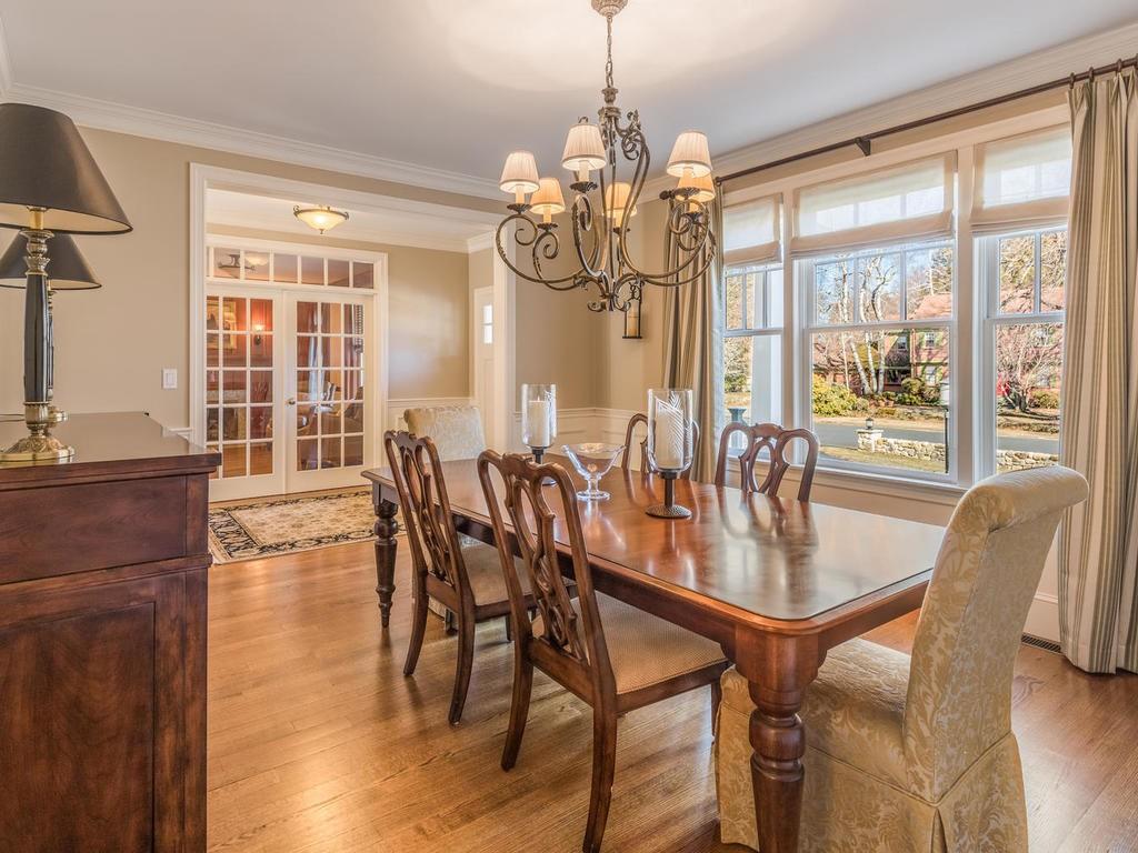 5 Saddle Club Road Lexington, MA 02420 - Photo 9 of 42 a dining room with wooden floor a chandelier a glass table and chairs